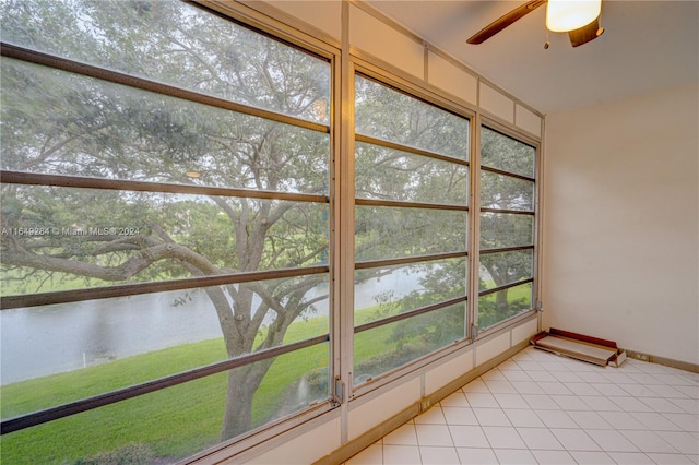 sunroom featuring a water view and ceiling fan