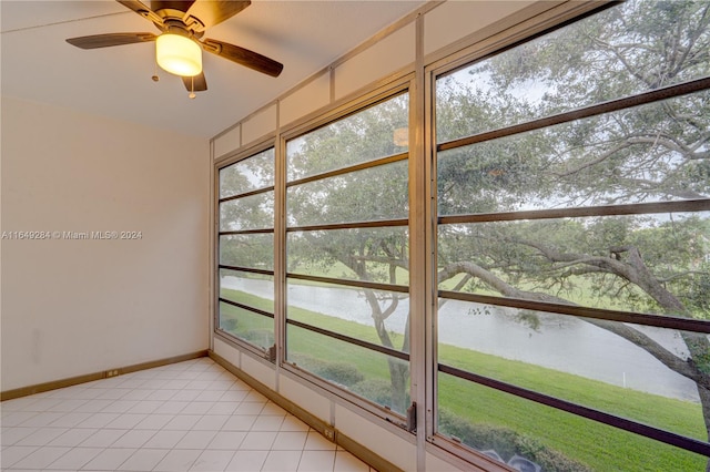 unfurnished sunroom with a water view and ceiling fan