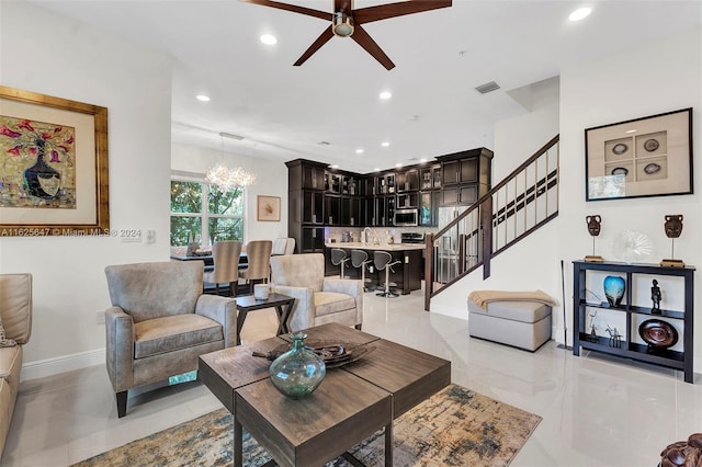 living room featuring ceiling fan with notable chandelier and light tile patterned floors