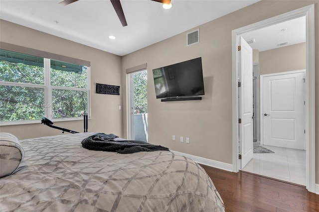 bedroom featuring dark tile patterned flooring, ceiling fan, and connected bathroom