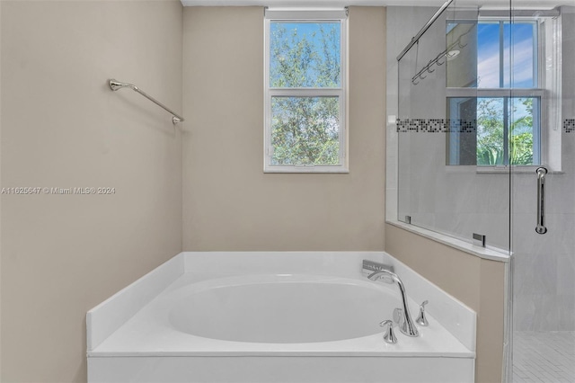 bathroom featuring separate shower and tub and a healthy amount of sunlight