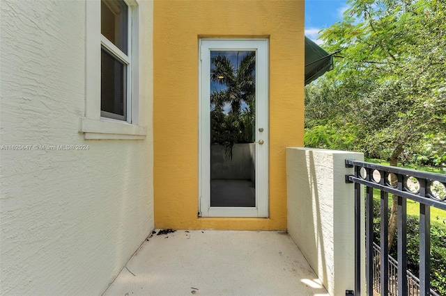 view of exterior entry featuring a balcony