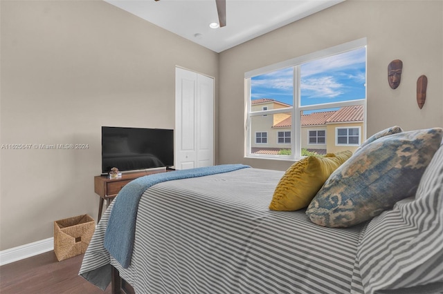 bedroom featuring dark wood-type flooring, ceiling fan, and a closet