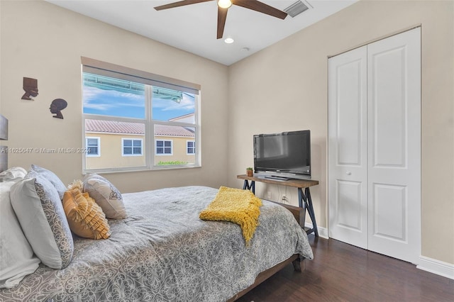 bedroom featuring dark wood-type flooring, a closet, and ceiling fan