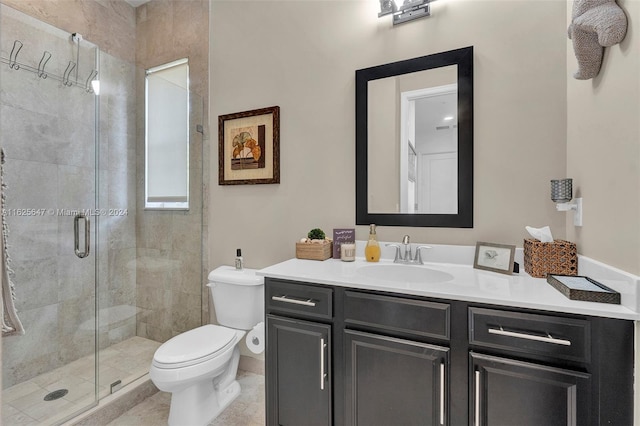 bathroom featuring a shower with door, vanity, toilet, and tile patterned floors