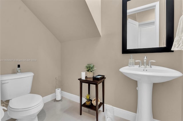 bathroom featuring vaulted ceiling, toilet, sink, and tile patterned flooring