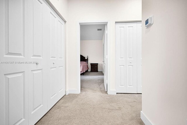 hallway with light colored carpet