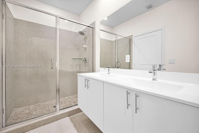 bathroom with tile patterned flooring, a shower with door, and vanity