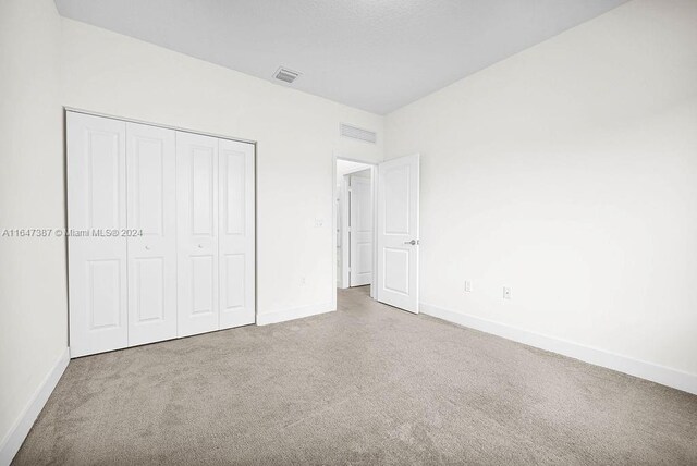 unfurnished bedroom with carpet and a closet