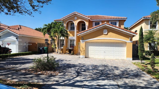 mediterranean / spanish home featuring a garage