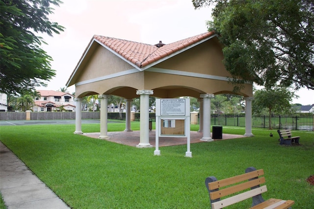 view of home's community featuring fence, a patio, and a lawn