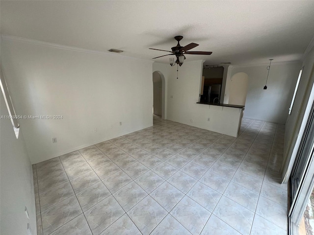 empty room featuring visible vents, arched walkways, ornamental molding, a ceiling fan, and light tile patterned flooring