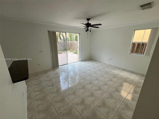 empty room with a ceiling fan, light tile patterned floors, ornamental molding, and visible vents
