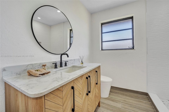 bathroom with vanity, toilet, and hardwood / wood-style floors