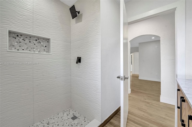 bathroom featuring vanity, hardwood / wood-style floors, and a tile shower