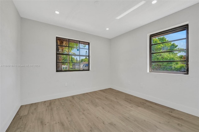 empty room with plenty of natural light and light hardwood / wood-style floors