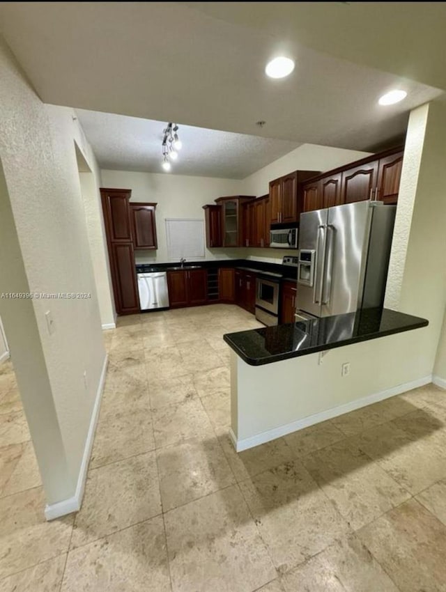 kitchen featuring appliances with stainless steel finishes, kitchen peninsula, and light tile patterned flooring