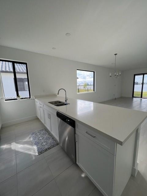 kitchen featuring kitchen peninsula, an inviting chandelier, sink, stainless steel dishwasher, and white cabinets