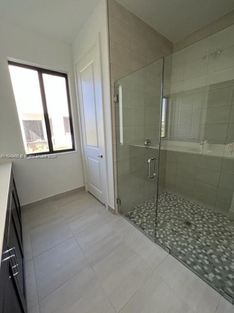 bathroom featuring tile patterned floors, an enclosed shower, and vanity