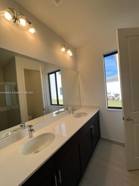 bathroom with vanity, toilet, walk in shower, and tile patterned flooring