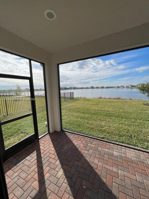 unfurnished sunroom featuring a water view