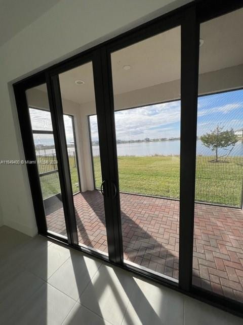 doorway featuring tile patterned floors and a water view