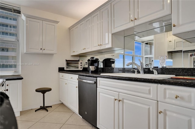 kitchen featuring white cabinets, light tile patterned floors, sink, and stainless steel dishwasher