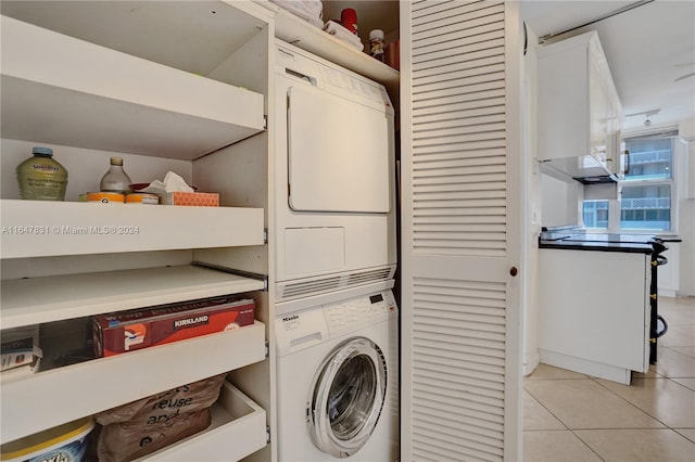 washroom featuring light tile patterned floors and stacked washer / dryer