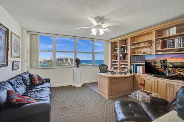 home office featuring light colored carpet, ceiling fan, and a textured ceiling