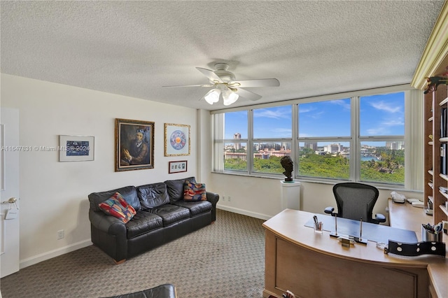 carpeted home office featuring a textured ceiling and ceiling fan