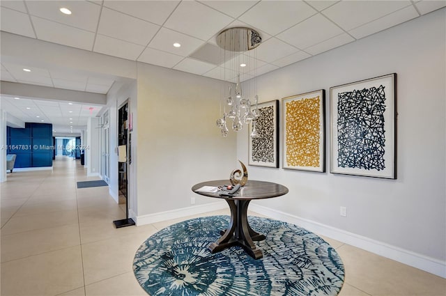 misc room with light tile patterned floors and a drop ceiling