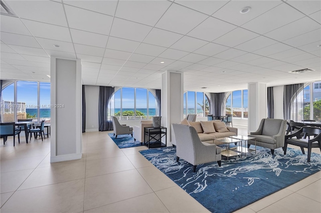 living room with expansive windows, tile patterned floors, and a water view