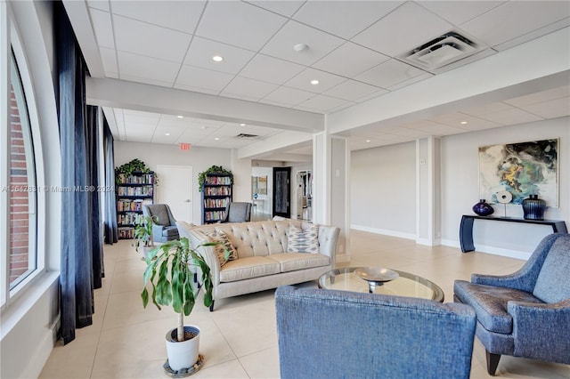 living room with light tile patterned floors and a drop ceiling