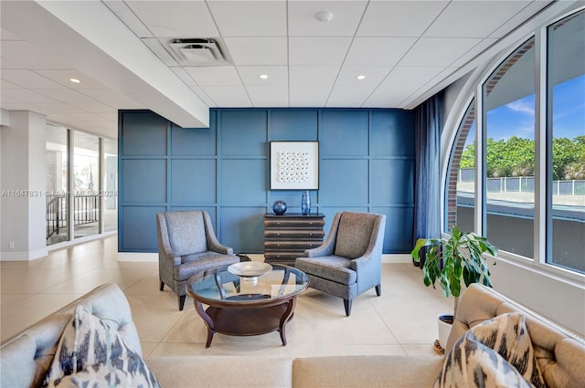 sitting room featuring a wall of windows and light tile patterned floors