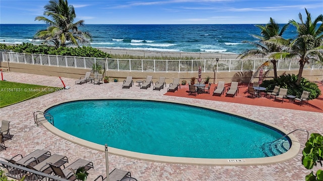 view of pool with a beach view, a patio, and a water view