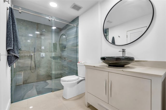 bathroom featuring vanity, a shower with shower door, toilet, and tile patterned flooring