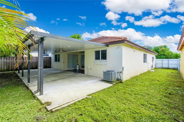 rear view of house featuring ceiling fan, cooling unit, a yard, and a patio