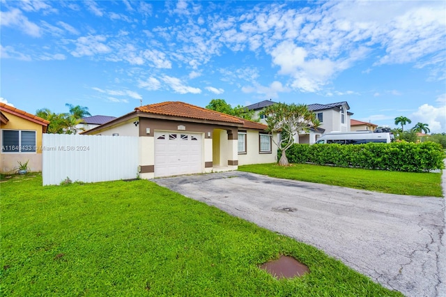 view of front of house with a front yard and a garage