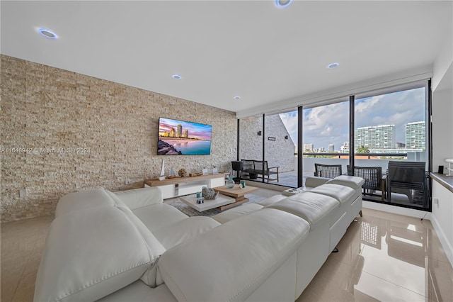 living room with light tile patterned floors and a wall of windows