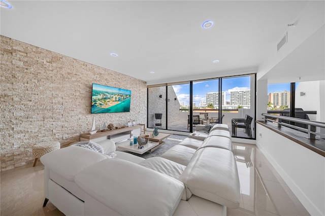 tiled living room featuring floor to ceiling windows