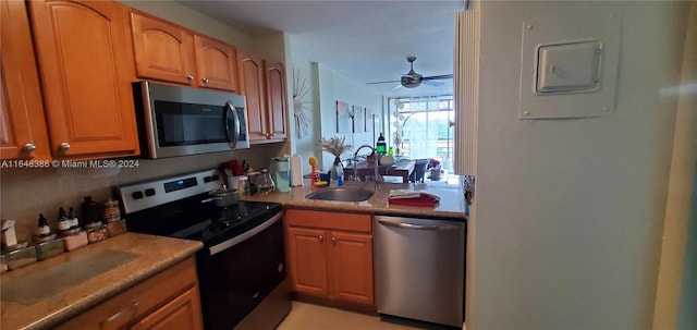 kitchen with appliances with stainless steel finishes, sink, and ceiling fan