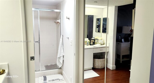 bathroom featuring an enclosed shower, hardwood / wood-style flooring, a textured ceiling, and vanity