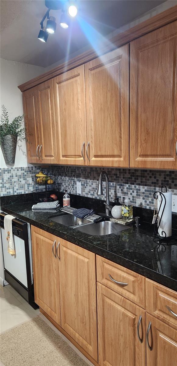 kitchen with dishwasher, tasteful backsplash, and sink