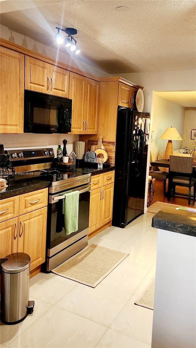 kitchen with black appliances, a textured ceiling, and light tile patterned floors