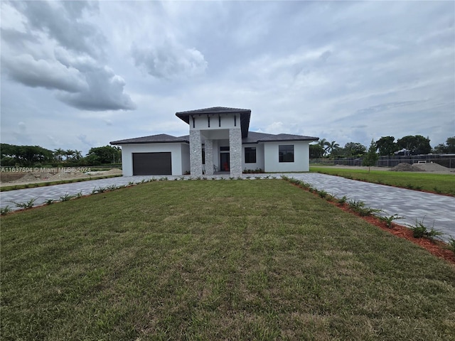 view of front of house featuring a garage and a front lawn