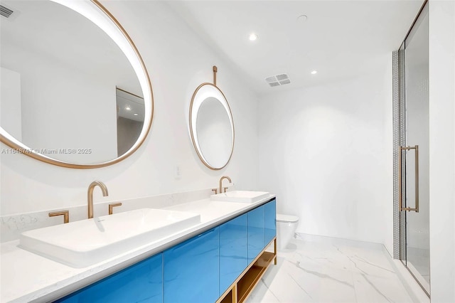 bathroom featuring marble finish floor, double vanity, a sink, and toilet