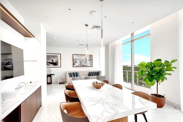 dining room with light speckled floor, expansive windows, and visible vents