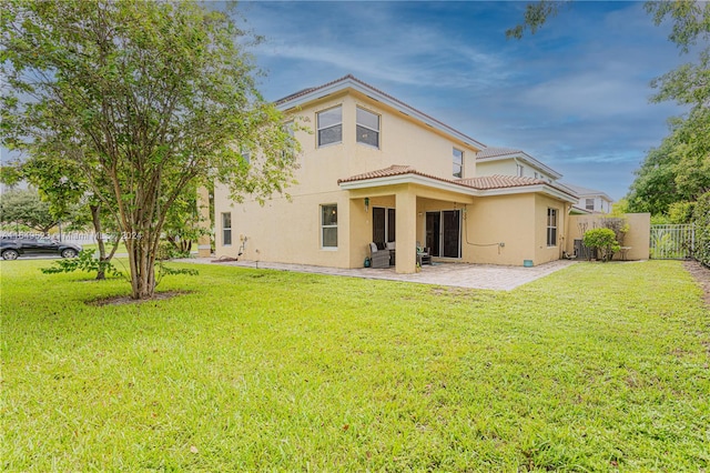 rear view of property with a yard and a patio area