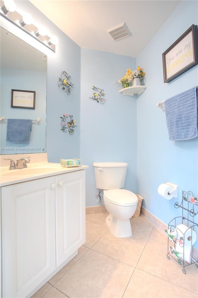 bathroom featuring tile patterned flooring, vanity, toilet, and a textured ceiling