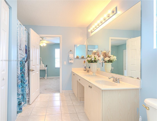 bathroom with vanity, toilet, tile patterned floors, and a textured ceiling